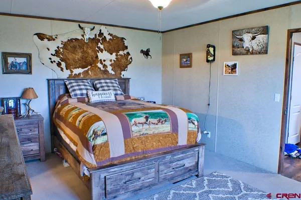 a bedroom with a bed and a painting on the wall