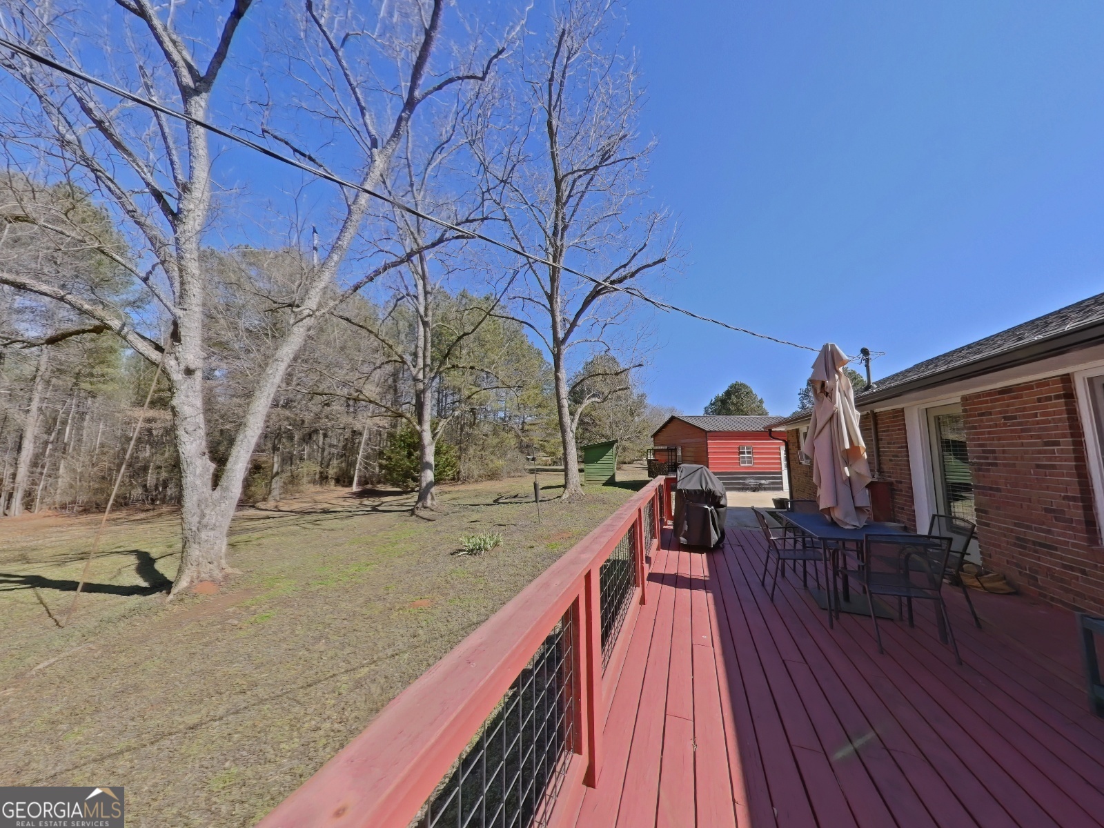 1491 Jack Malcolm Road Madison, GA 30650 - Photo 21 of 22 a view of a house with wooden deck next to a yard