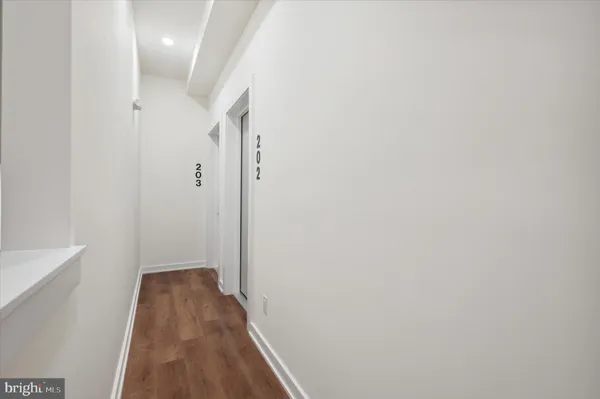 a view of a hallway with wooden floor