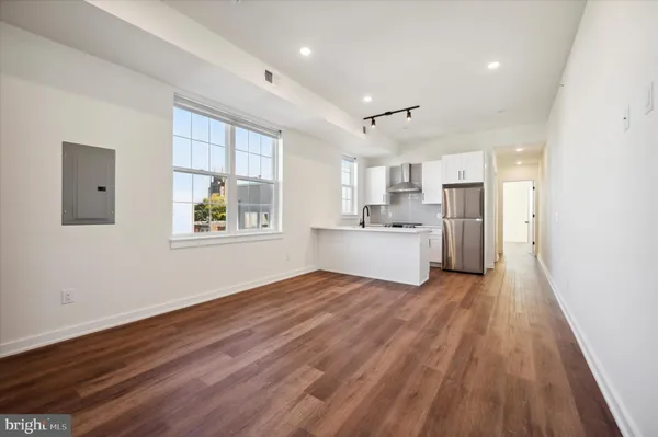 a view of a kitchen with a fridge wooden floor and a window