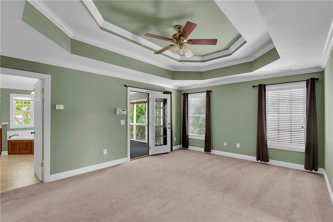 406 Hopewell Ridge Anderson, SC 29621 - Photo 18 of 46 This spacious primary bedroom features tray ceilings and ample natural light, with direct access to a private porch.