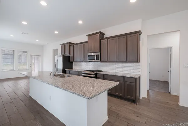 a kitchen with stainless steel appliances granite countertop a stove a sink and a refrigerator