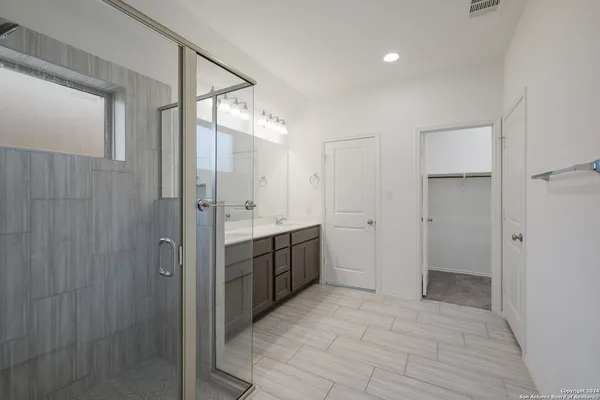 a bathroom with a double vanity sink mirror and shower