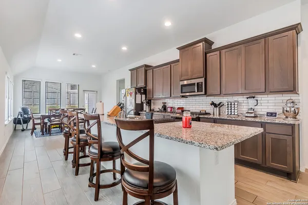 a kitchen with a dining table chairs and sink