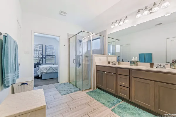 a spacious bathroom with a shower sink and mirror