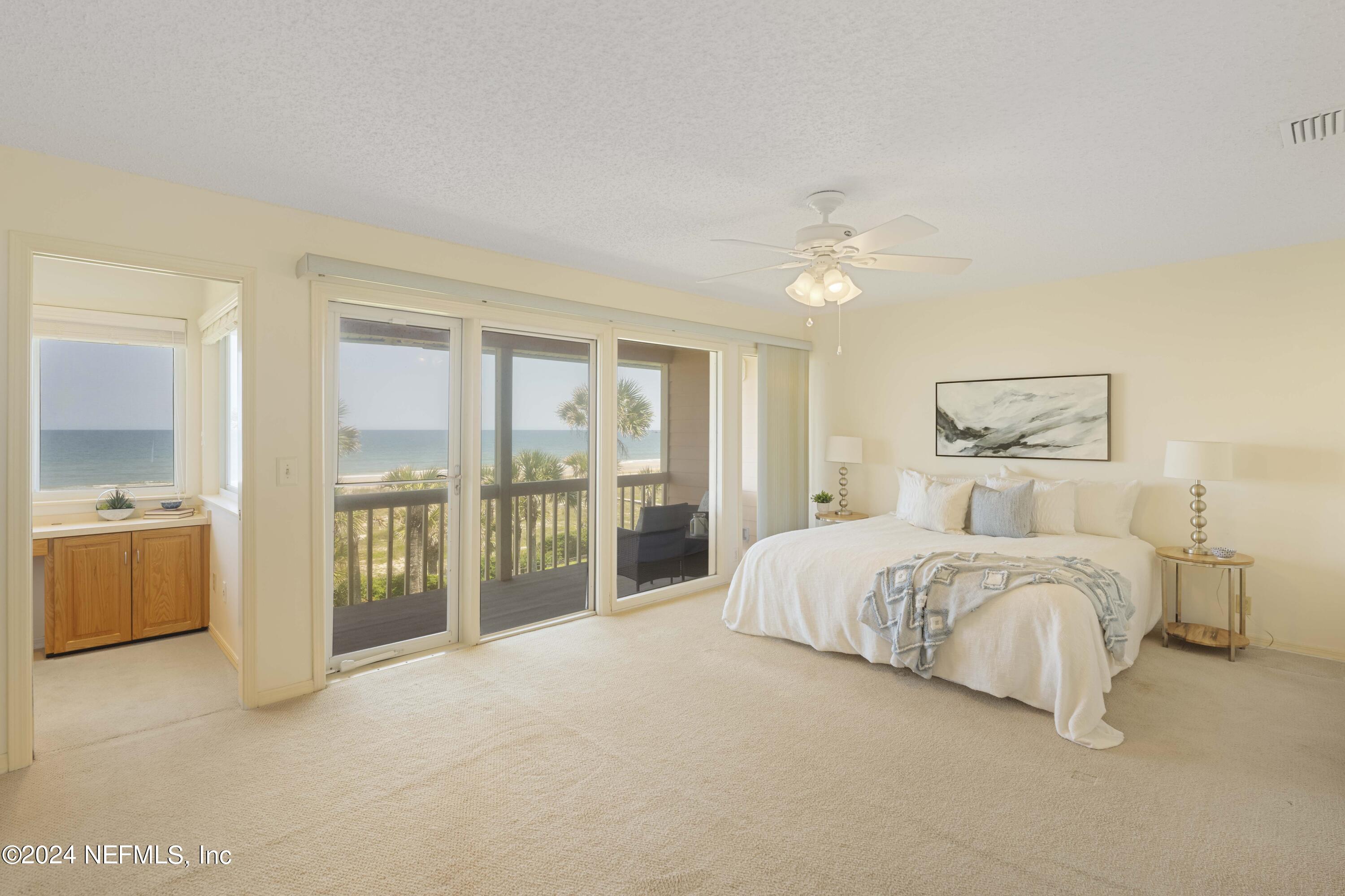 2279 Seminole Road, Unit 4 Atlantic Beach, FL 32233 - Photo 15 of 45 a spacious bedroom with a large bed and a chandelier