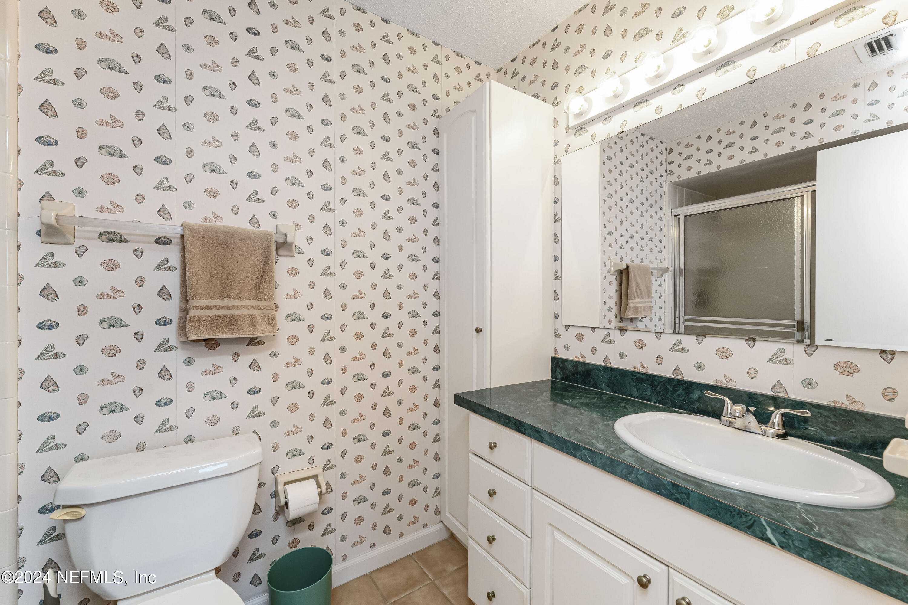 2279 Seminole Road, Unit 4 Atlantic Beach, FL 32233 - Photo 24 of 45 a bathroom with a granite countertop toilet sink and mirror