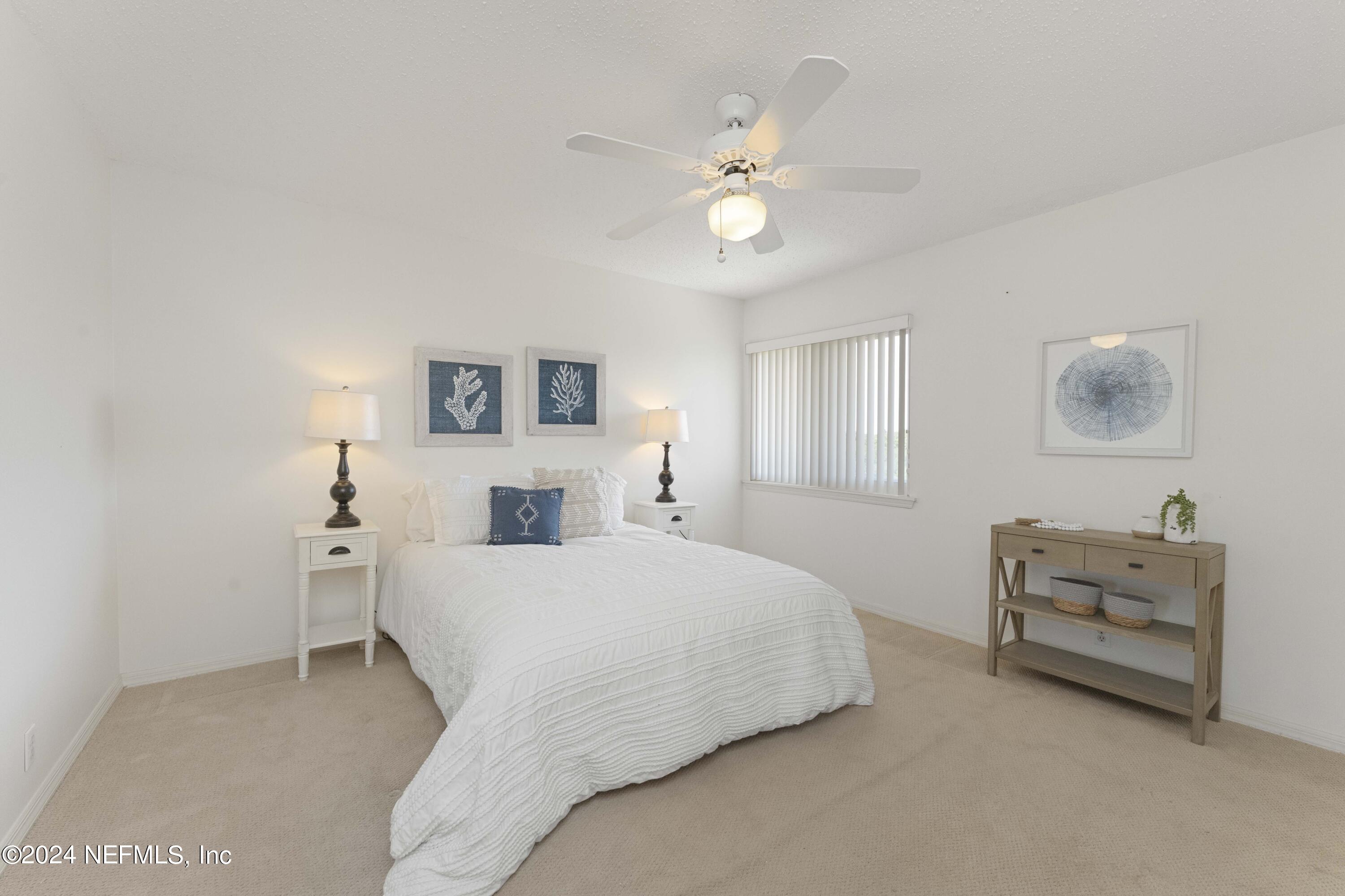 2279 Seminole Road, Unit 4 Atlantic Beach, FL 32233 - Photo 28 of 45 a bedroom with a bed and a chandelier