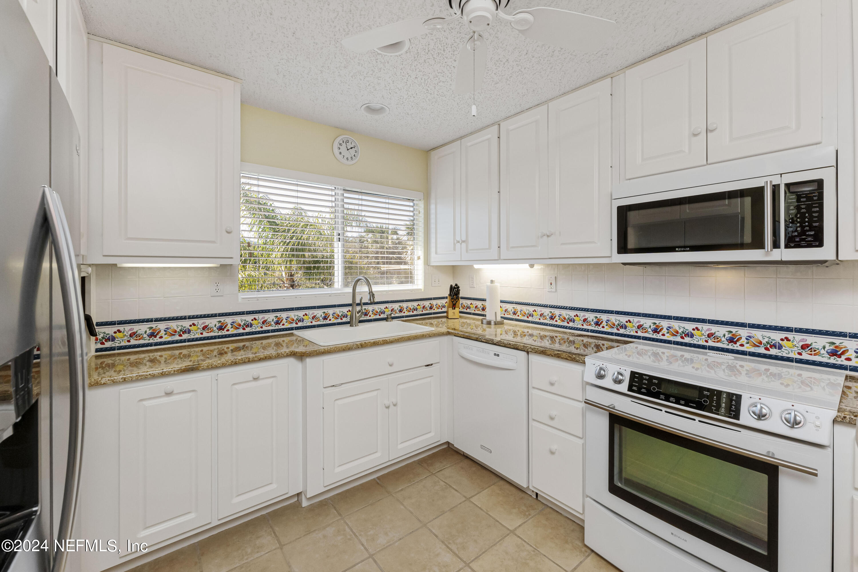 2279 Seminole Road, Unit 4 Atlantic Beach, FL 32233 - Photo 4 of 45 a kitchen with white cabinets appliances and a window