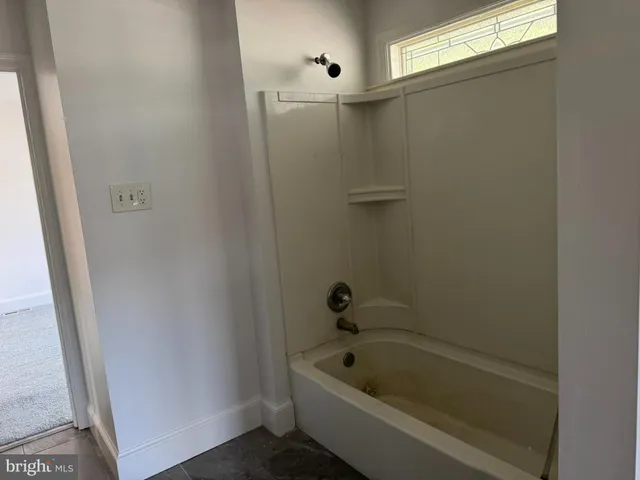 a view of an empty room and a ceiling fan