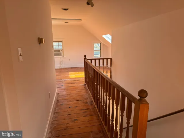 a view of an empty room with wooden floor and cabinet