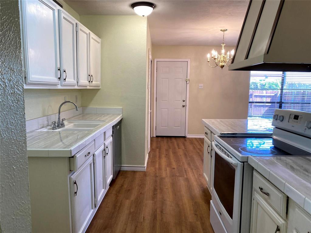 a kitchen with stainless steel appliances granite countertop a sink a stove and a wooden floors