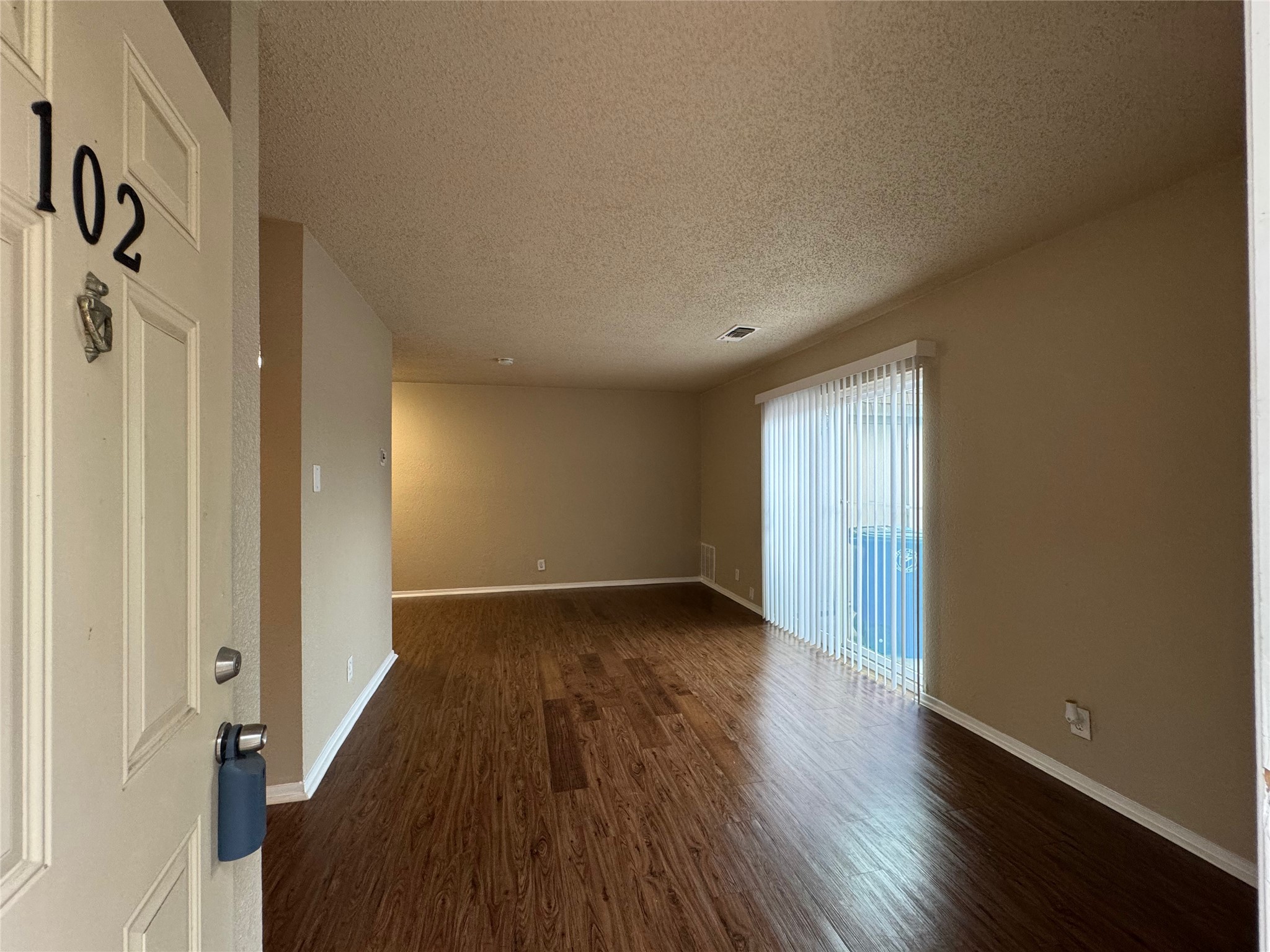 5006 West Wind Trail, Unit 102 Austin, TX 78745 - Photo 2 of 20 a view of a room with wooden floor and a window
