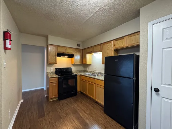 a kitchen with a refrigerator and a stove top oven