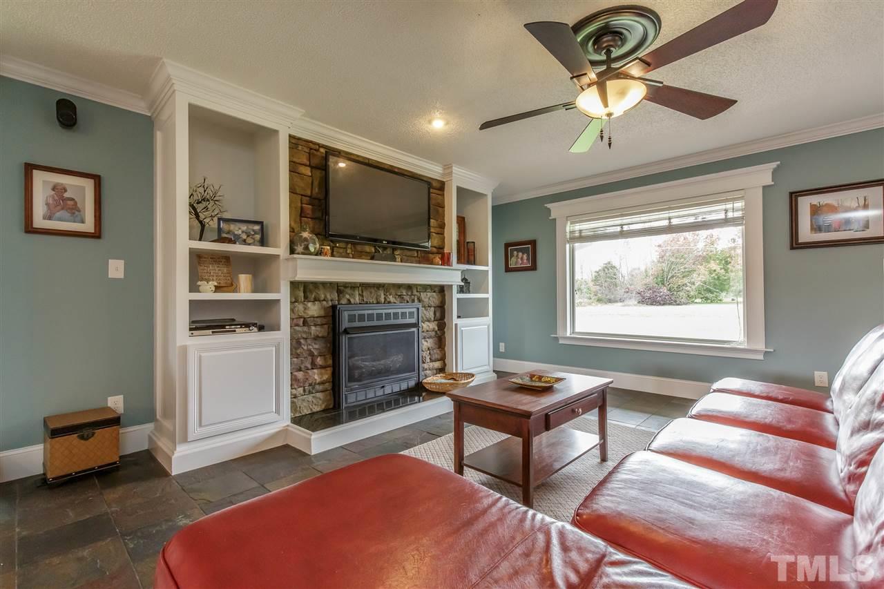 1117 Boone Road Burlington, NC 27217 - Photo 4 of 30 CUSTOM STONE surround fireplace flanked by built-in bookcase and cabinet