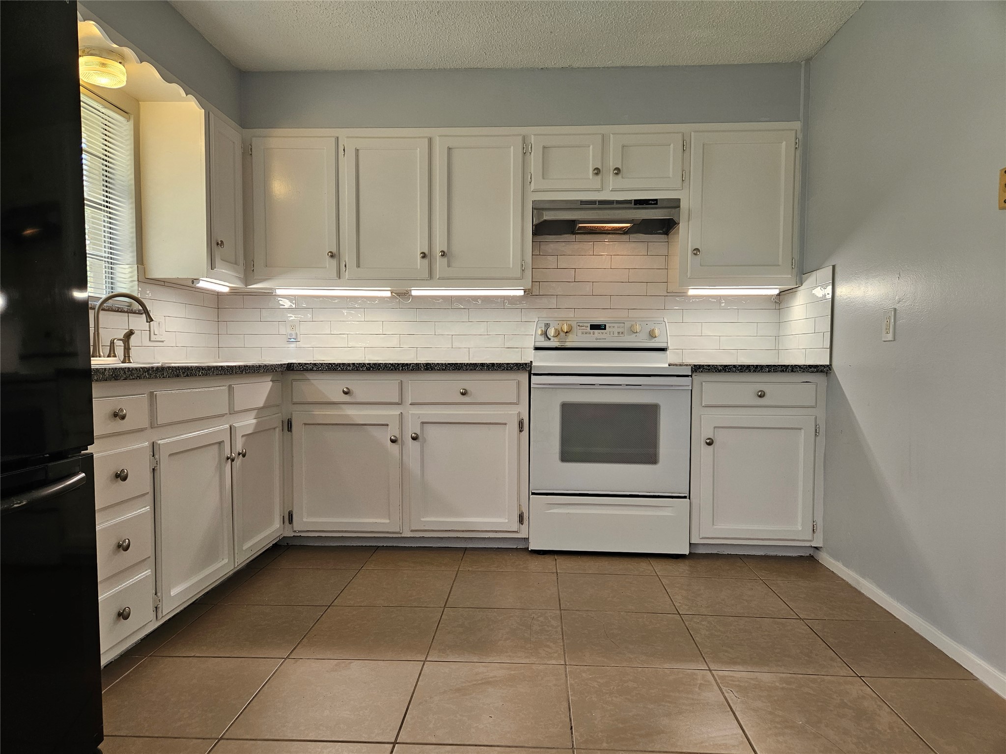 806 Ranch Road, Unit A Georgetown, TX 78628 - Photo 5 of 24 A compact kitchen with updated countertops and a classic subway tile backsplash awaits your culinary touch.