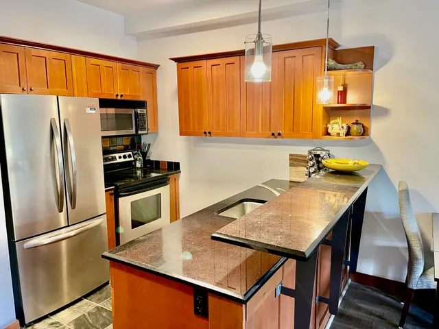 a kitchen with stainless steel appliances a stove refrigerator sink and microwave