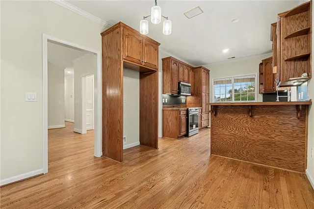 a view of a kitchen with wooden floor and a refrigerator