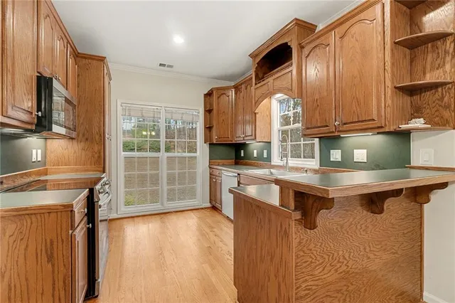 a kitchen with stainless steel appliances granite countertop a stove a sink and a microwave