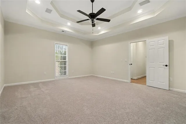 an empty room with ceiling fan and window