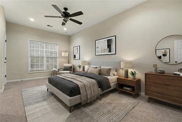 a spacious bedroom with a bed a dresser and a large window