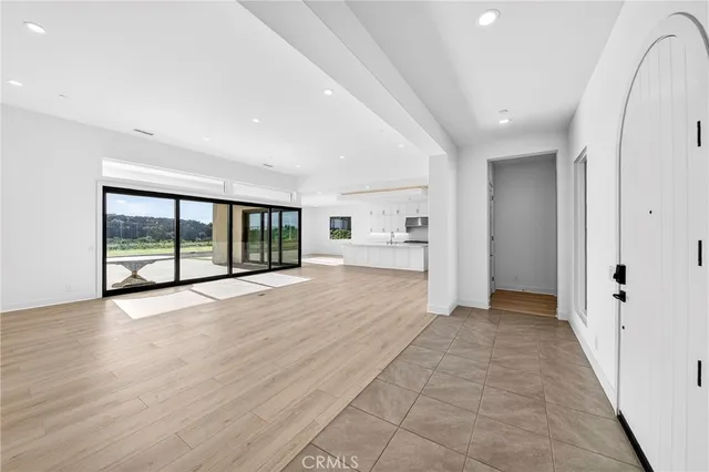 a large living room with a large window and kitchen view