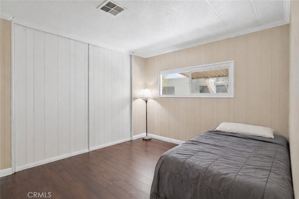 22838 Bear Valley Road, Unit 64 Apple Valley, CA 92308 - Photo 11 of 22 a bedroom with a bed and a painting on the wall