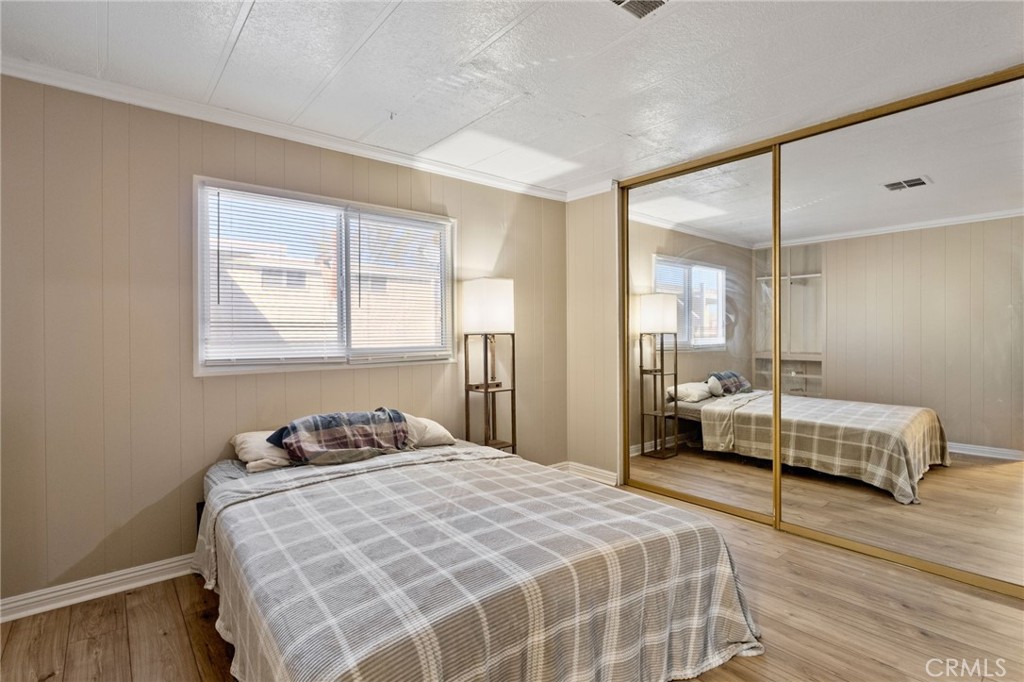 22838 Bear Valley Road, Unit 64 Apple Valley, CA 92308 - Photo 12 of 22 a bedroom with a bed and wooden floor
