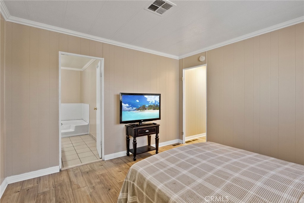 22838 Bear Valley Road, Unit 64 Apple Valley, CA 92308 - Photo 13 of 22 a bedroom with a bed and a flat screen tv