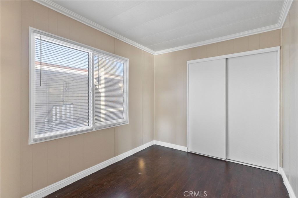 22838 Bear Valley Road, Unit 64 Apple Valley, CA 92308 - Photo 6 of 22 an empty room with wooden floor and windows