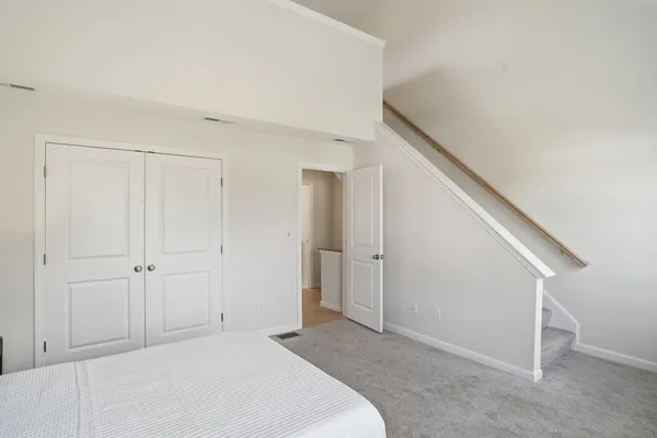 a bedroom with a bed and a painting on the wall
