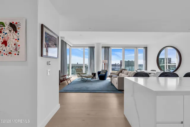a living room with furniture a mirror and white walls
