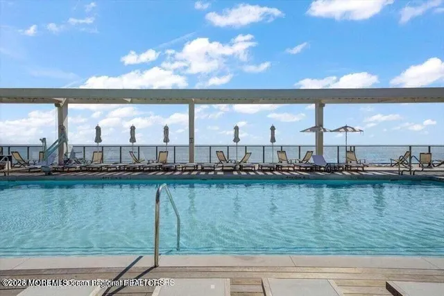 a view of a kitchen with refrigerator and wooden floor
