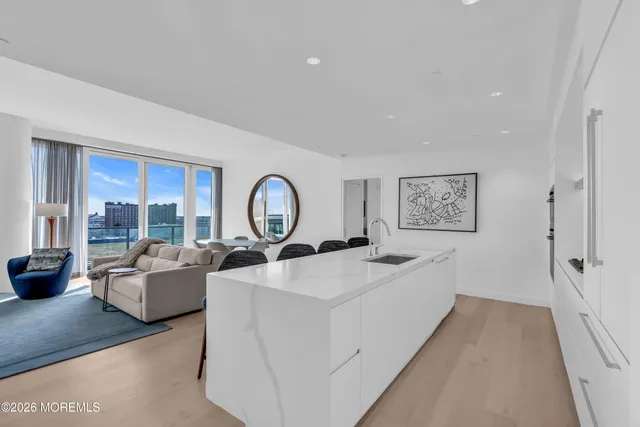 a kitchen with stainless steel appliances kitchen island granite countertop a table chairs and a refrigerator