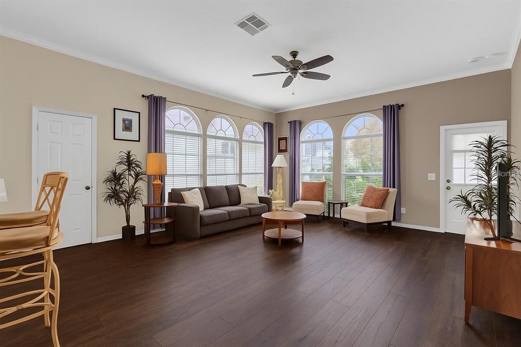 604 Nadina Place Celebration, FL 34747 - Photo 12 of 32 a living room with furniture floor to ceiling window and a flat screen tv