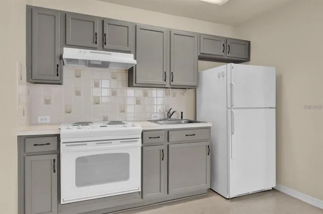 a kitchen with cabinets stainless steel appliances and sink