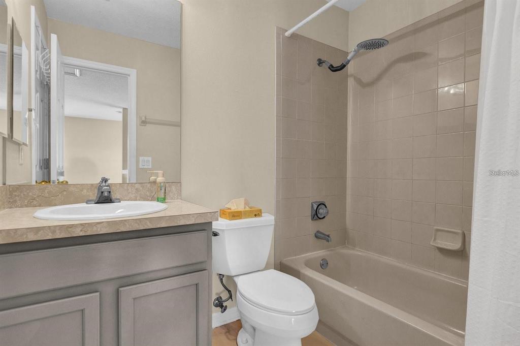 604 Nadina Place Celebration, FL 34747 - Photo 26 of 32 a bathroom with a bath tub sink mirror vanity and toilet