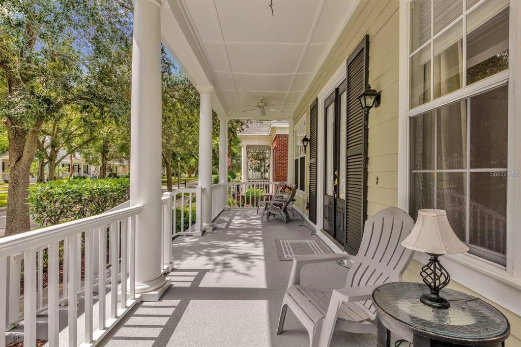 604 Nadina Place Celebration, FL 34747 - Photo 4 of 32 a porch with chairs and wooden floor