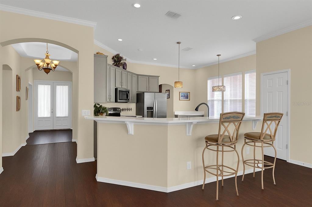 604 Nadina Place Celebration, FL 34747 - Photo 7 of 32 a kitchen with stainless steel appliances a table and chairs in it