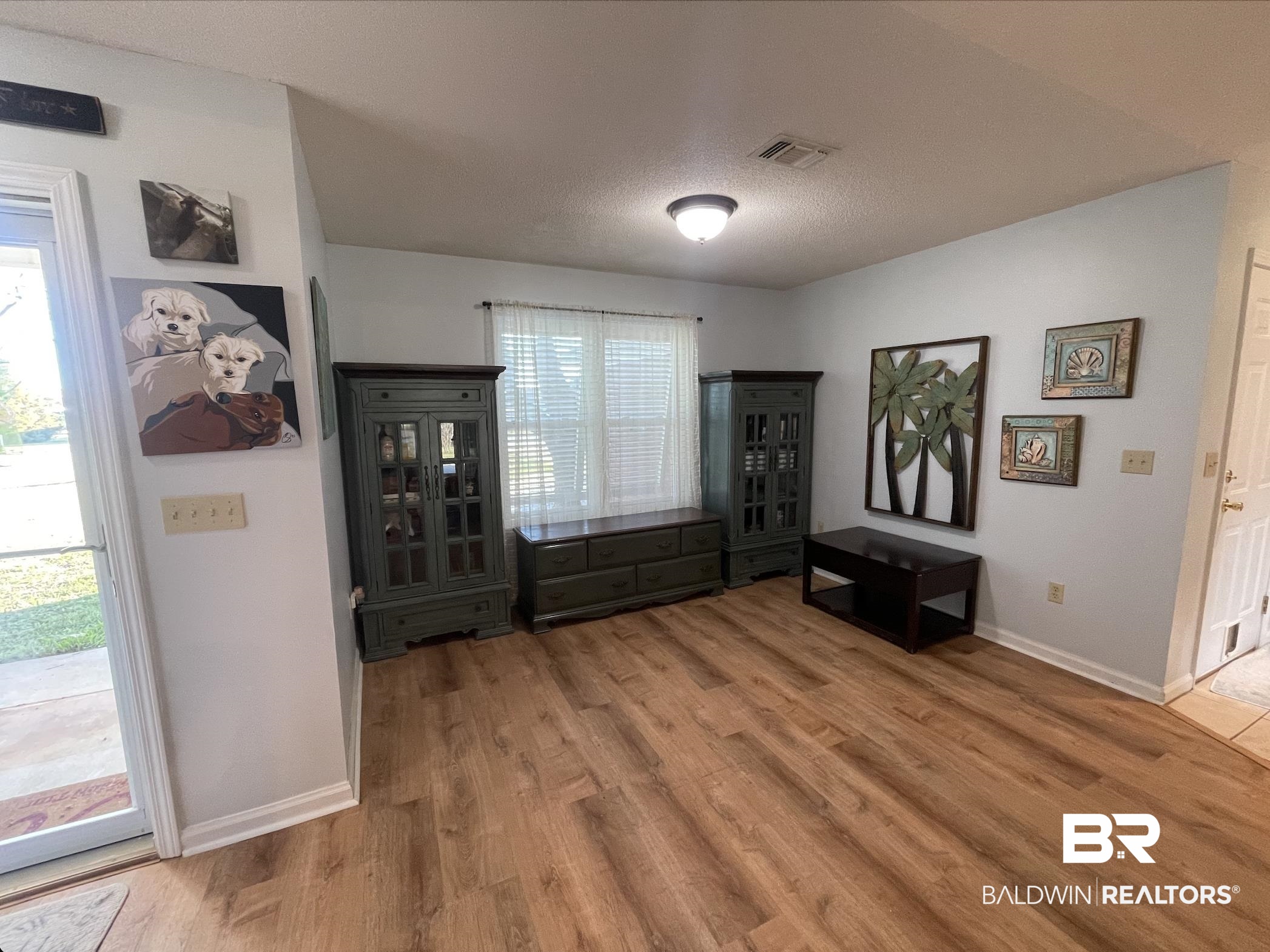 17643 East View Loop Foley, AL 36535 - Photo 3 of 25 Living area featuring a textured ceiling, wood finished floors, visible vents, and baseboards
