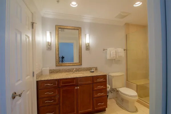 a bathroom with a granite countertop toilet sink and mirror