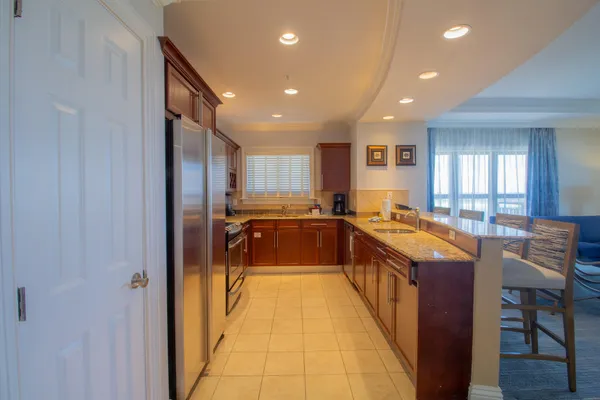 a large kitchen with kitchen island granite countertop a large counter top and stainless steel appliances
