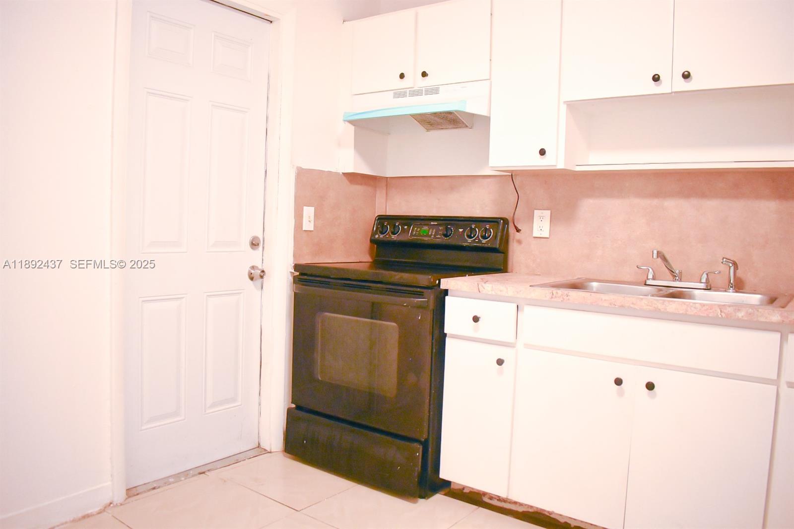 2265 Northwest 98th Street, Unit 2265 Miami, FL 33147 - Photo 13 of 15 a kitchen with cabinets and white appliances