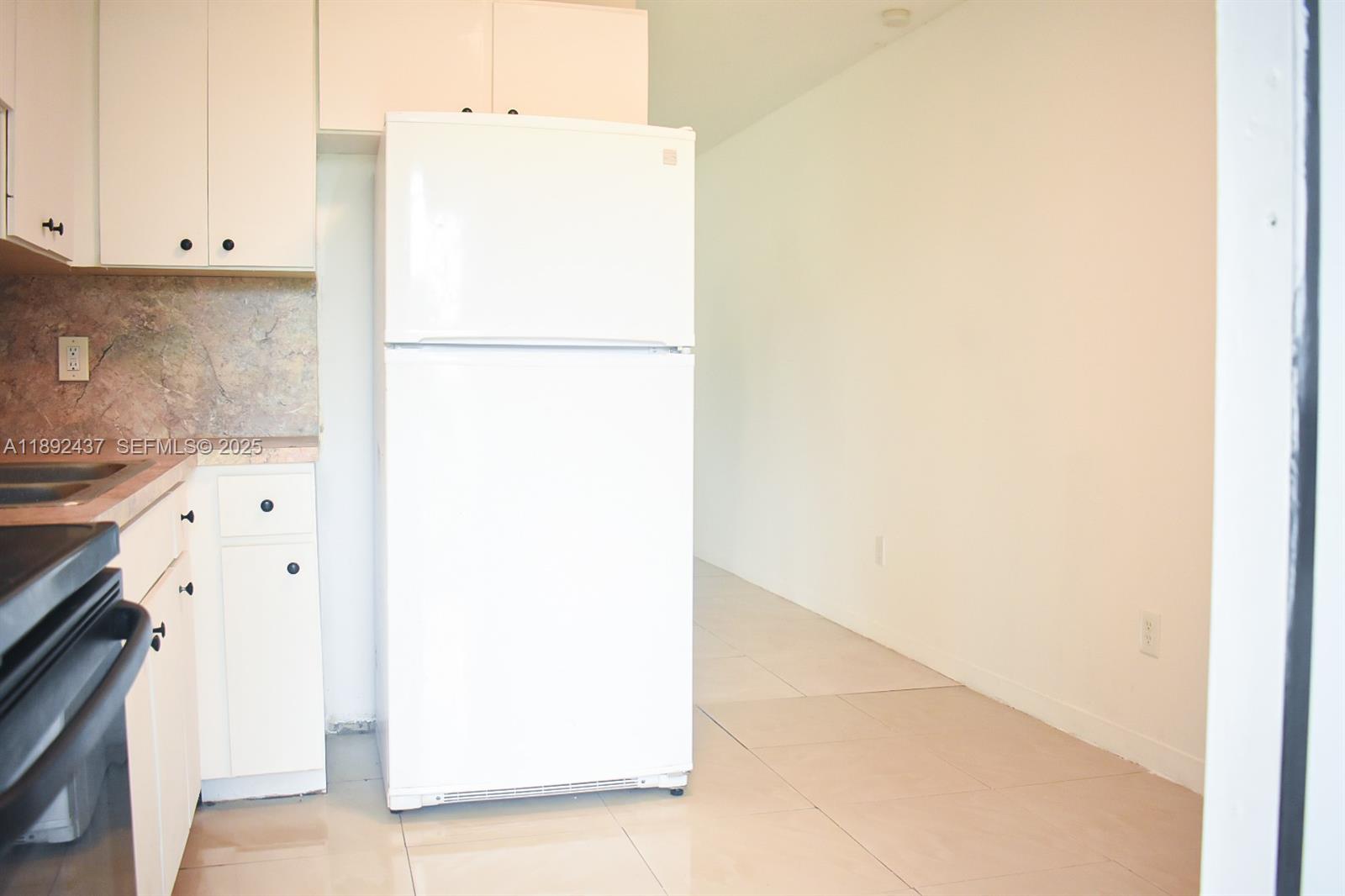 2265 Northwest 98th Street, Unit 2265 Miami, FL 33147 - Photo 14 of 15 a kitchen with a refrigerator and a stove