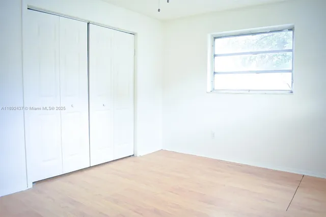 a view of a small space with wooden floor and a window