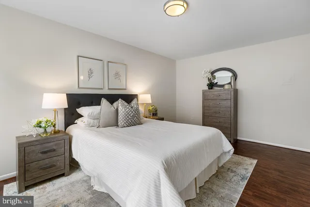 a bedroom with a bed and painting on the wall