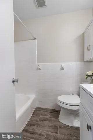 a white toilet sitting next to a bath tub