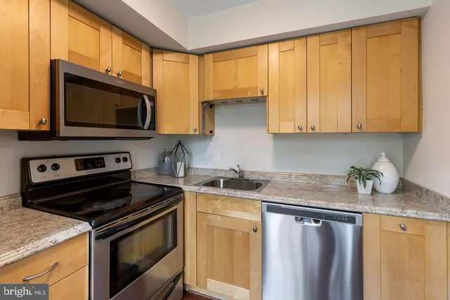 a kitchen with granite countertop a stove sink and microwave