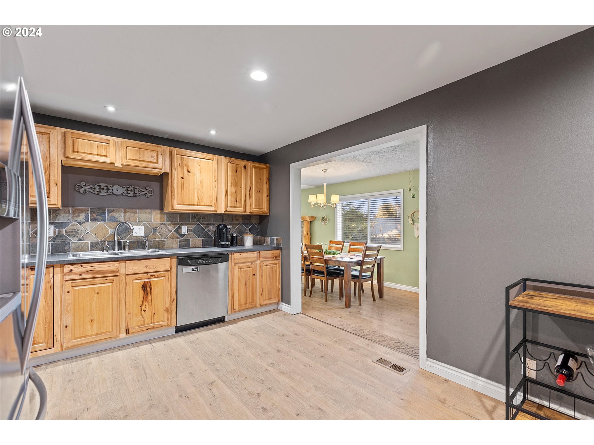 3825 Southeast 6th Street Gresham, OR 97080 - Photo 20 of 37 a open kitchen with granite countertop a sink a stove a dining table and chairs