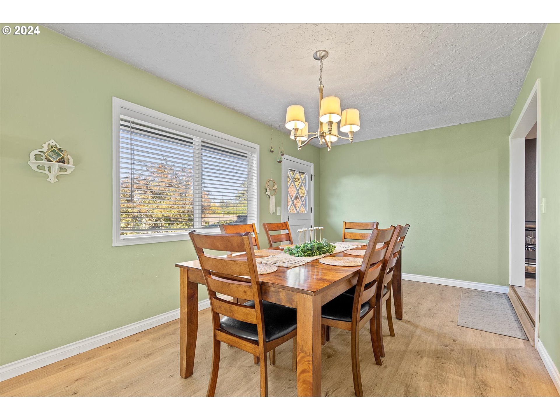 3825 Southeast 6th Street Gresham, OR 97080 - Photo 23 of 37 a view of a dining room with furniture a chandelier and wooden floor